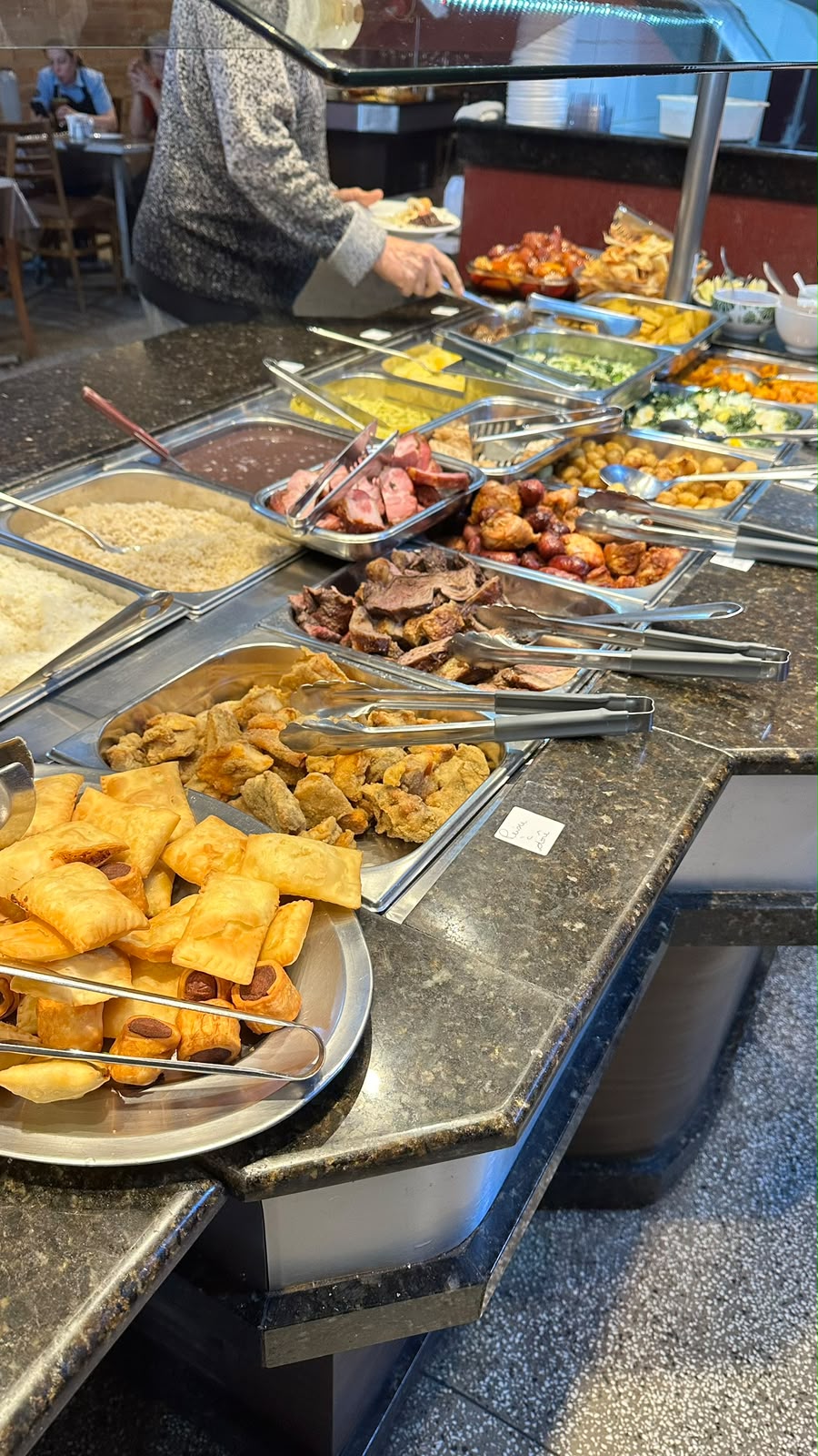 Balcão quente do buffet com carnes, frituras e acompanhamentos
