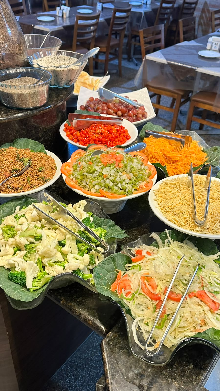 Variedade de saladas, grãos e frutas no buffet